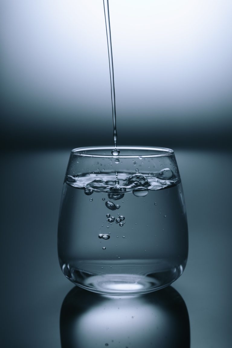 Minimalistic photo of water being poured into a glass